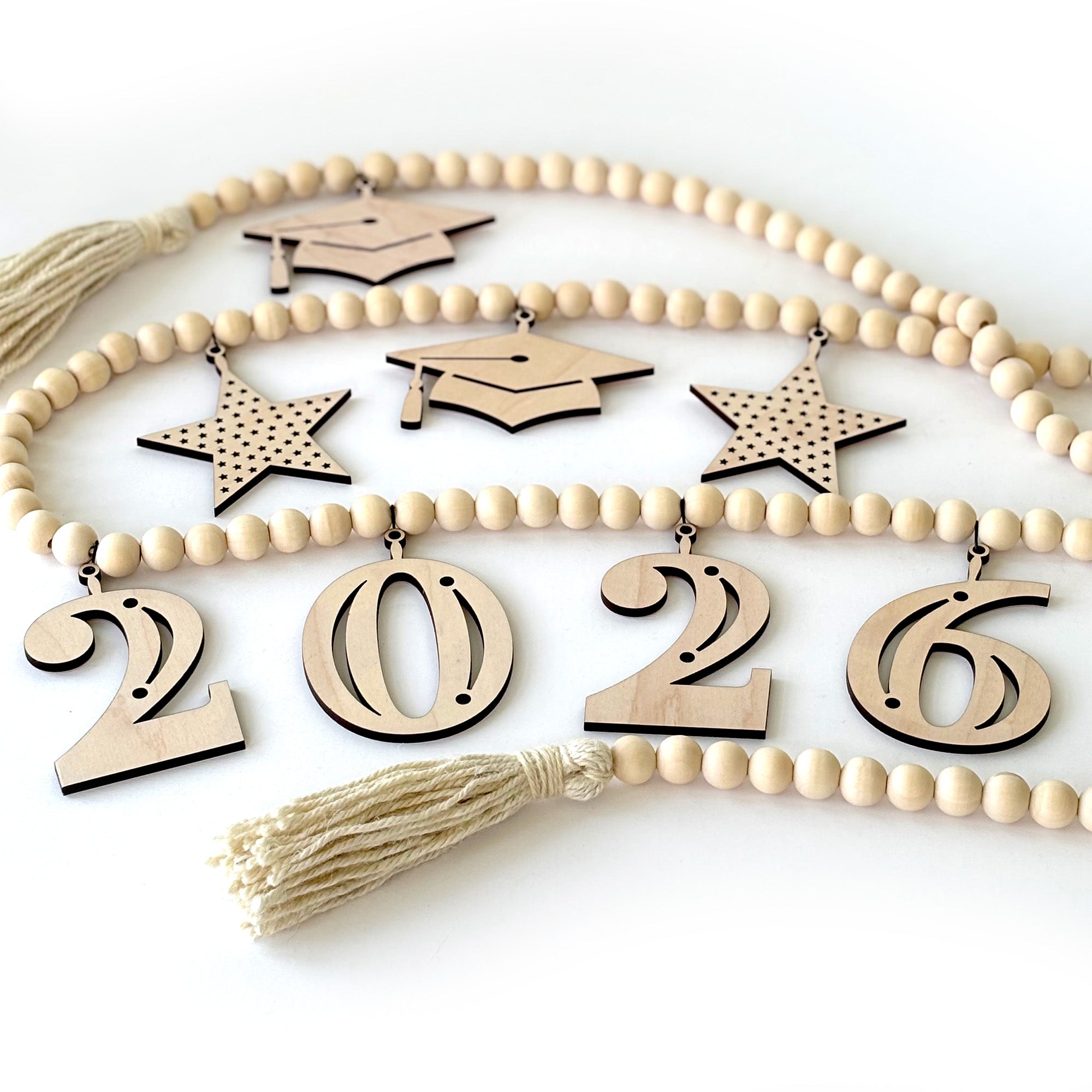 2026 Graduation Garland on table. Garland is made from wood beads with grad cap and star charms.