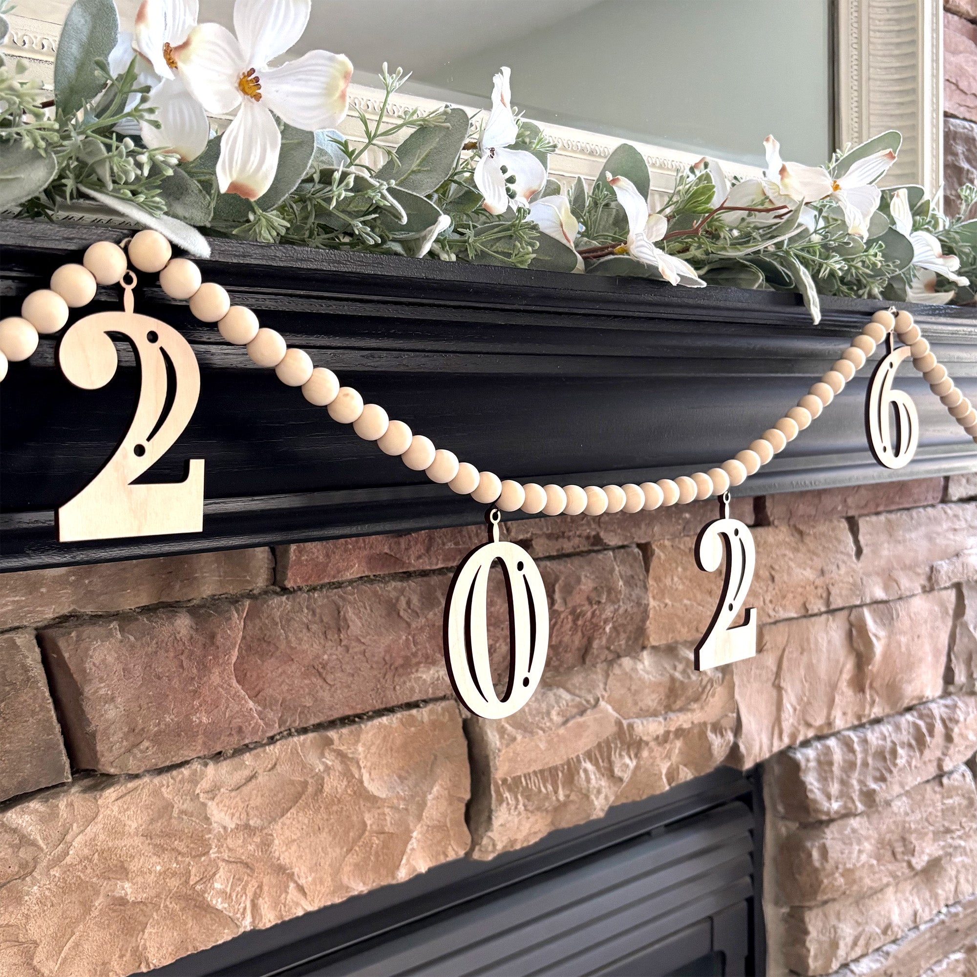 2026 Graduation Garland on Fireplace Mantel. Garland is made from wood beads with charms that read 2026.