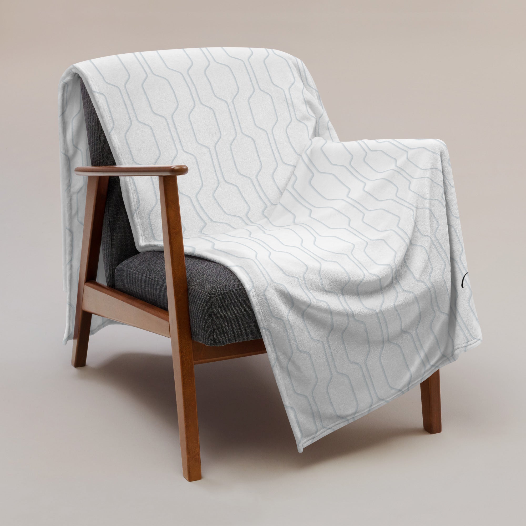 Personalized super soft blanket with blue contemporary pattern draped over a chair. Blanket has text that says, "a hug from Austin.” Support gift for son or daughter at college.