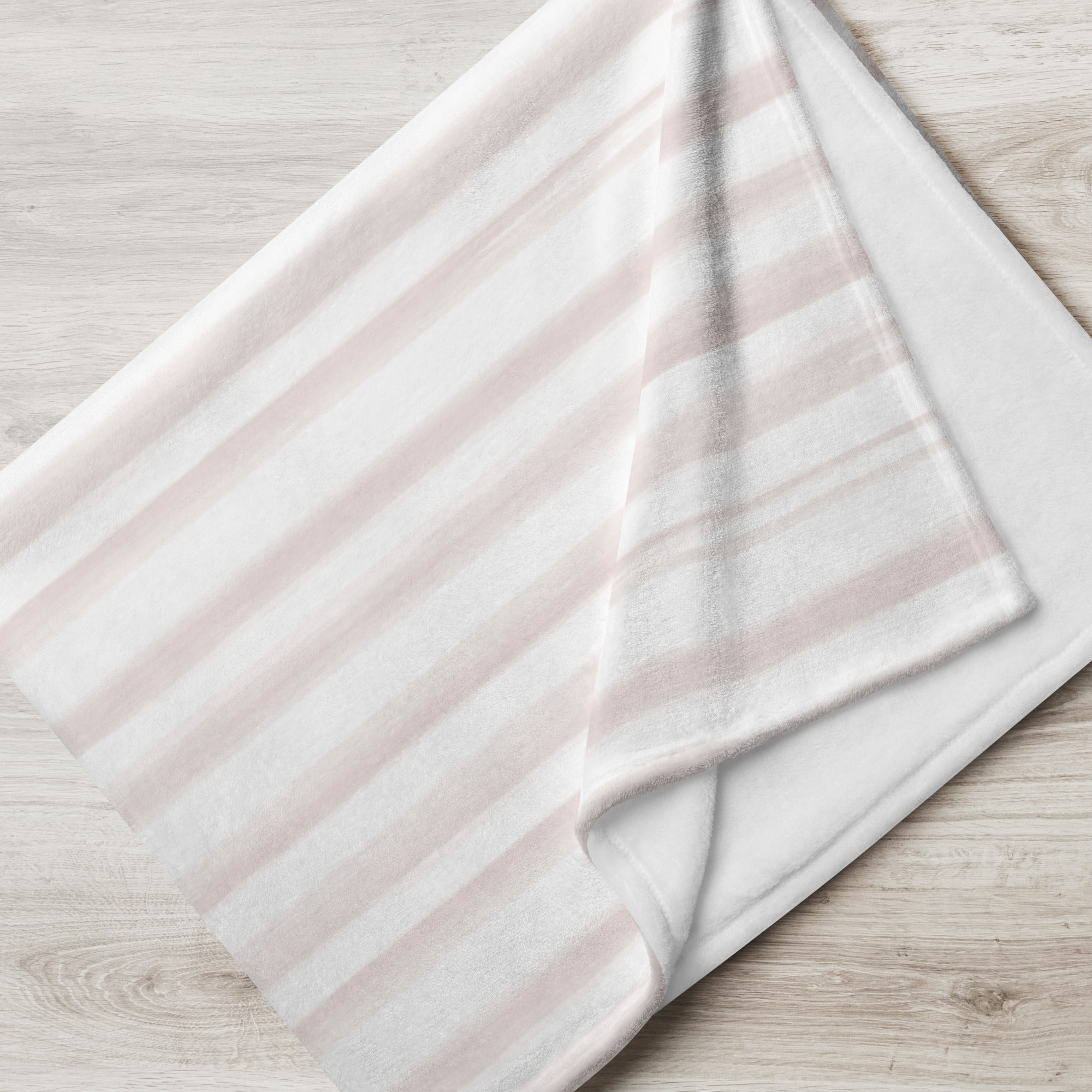 Folded blanket with pale pink modern stripes pattern. Blanket has text that says, "a hug from Isabella.” Sympathy gift for loss of child.