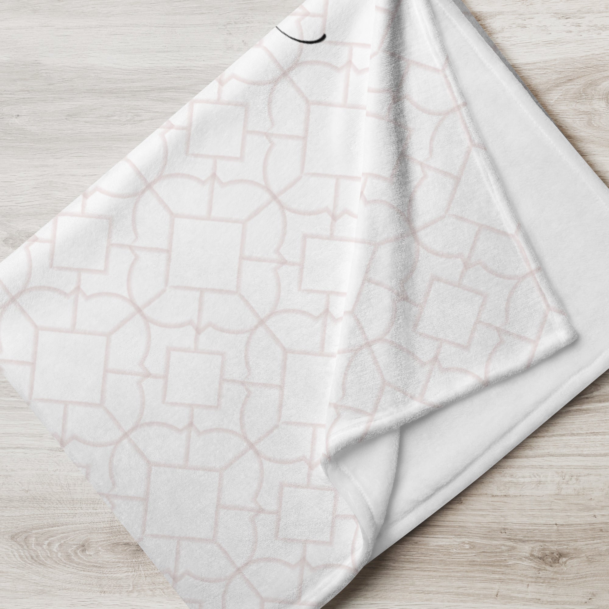 Folded blanket with pale pink tile pattern. Blanket has text that says, "a hug from Grandma.” Sympathy gift for loss of child.
